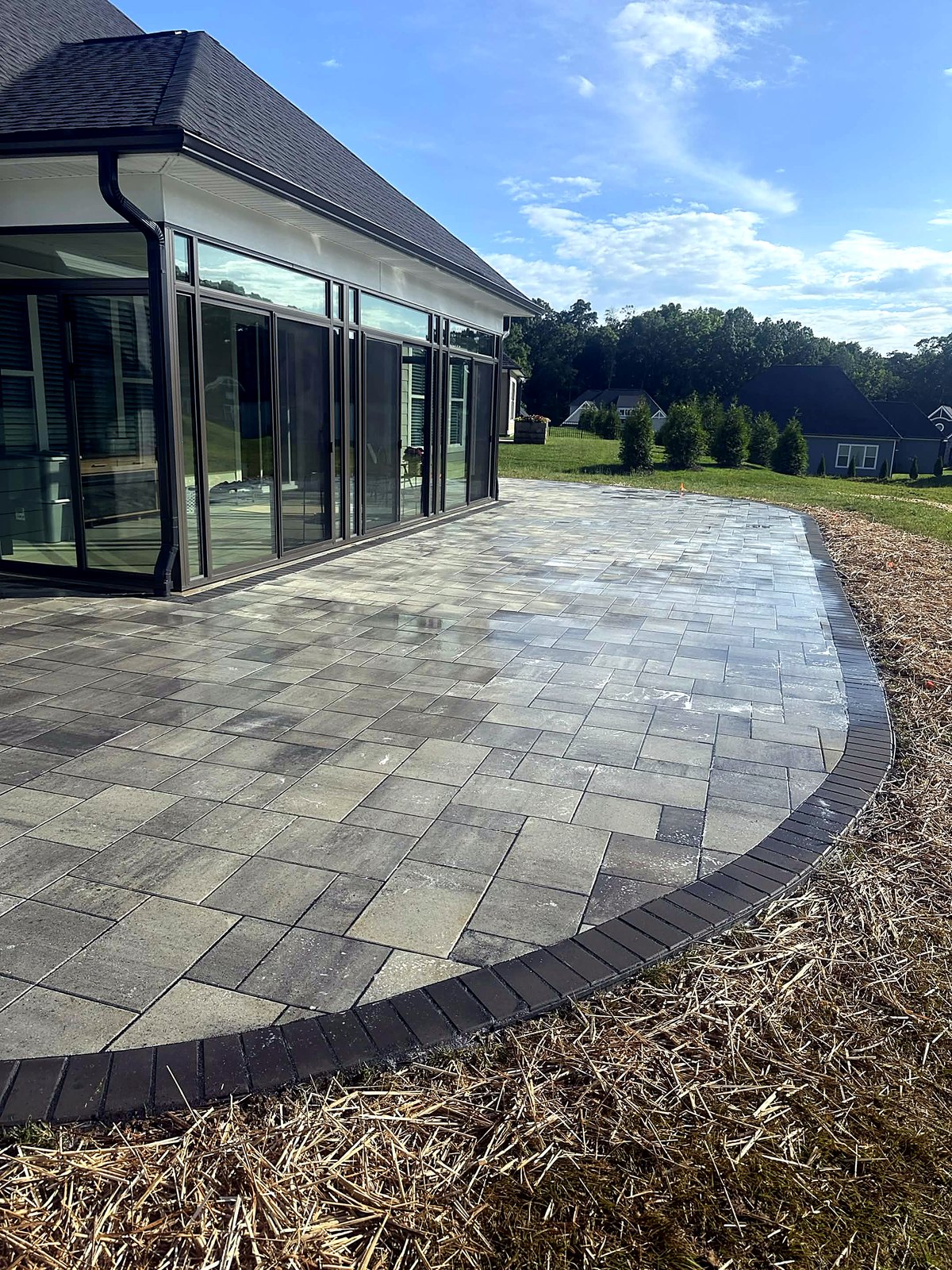 Curved paver patio with dark border built by Caylor
