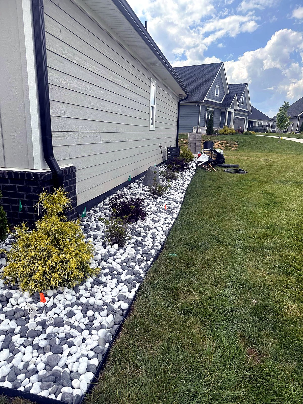 White stone bed with fresh plantings along a home